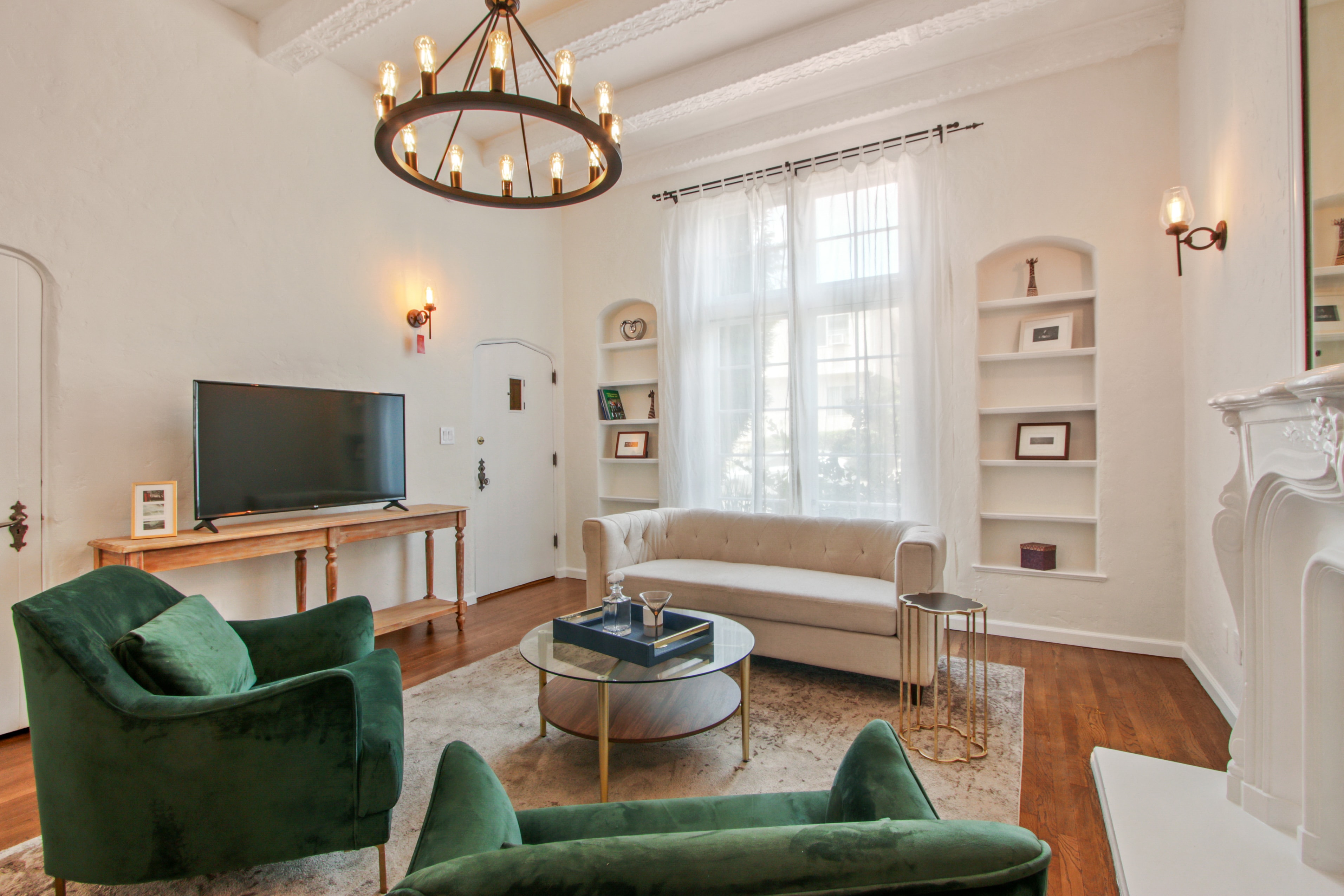 Living room with vaulted ceilings, chandelier and green velvet chairs
