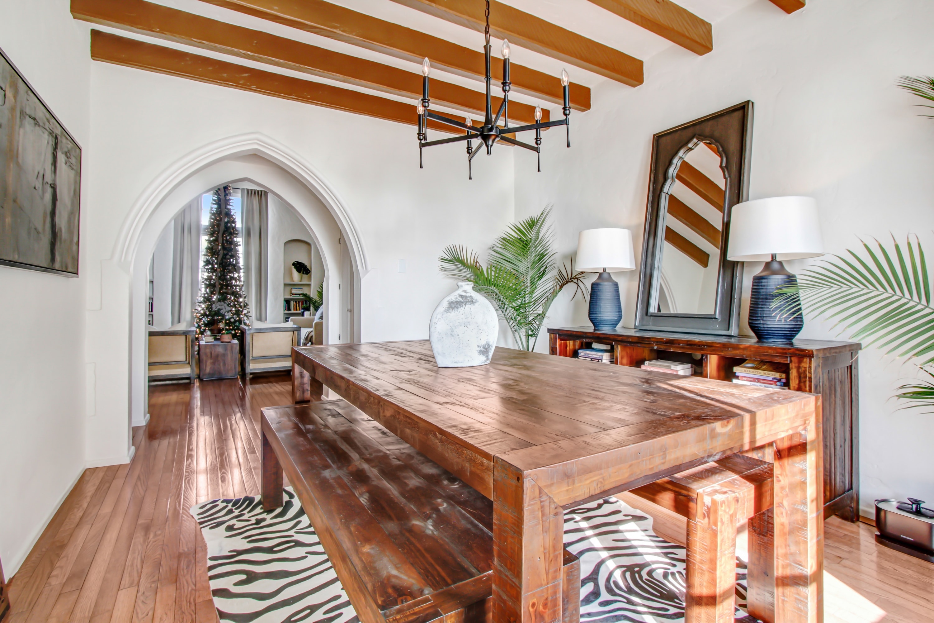 Formal dining room with exposed wood beams and Gothic arched doorway