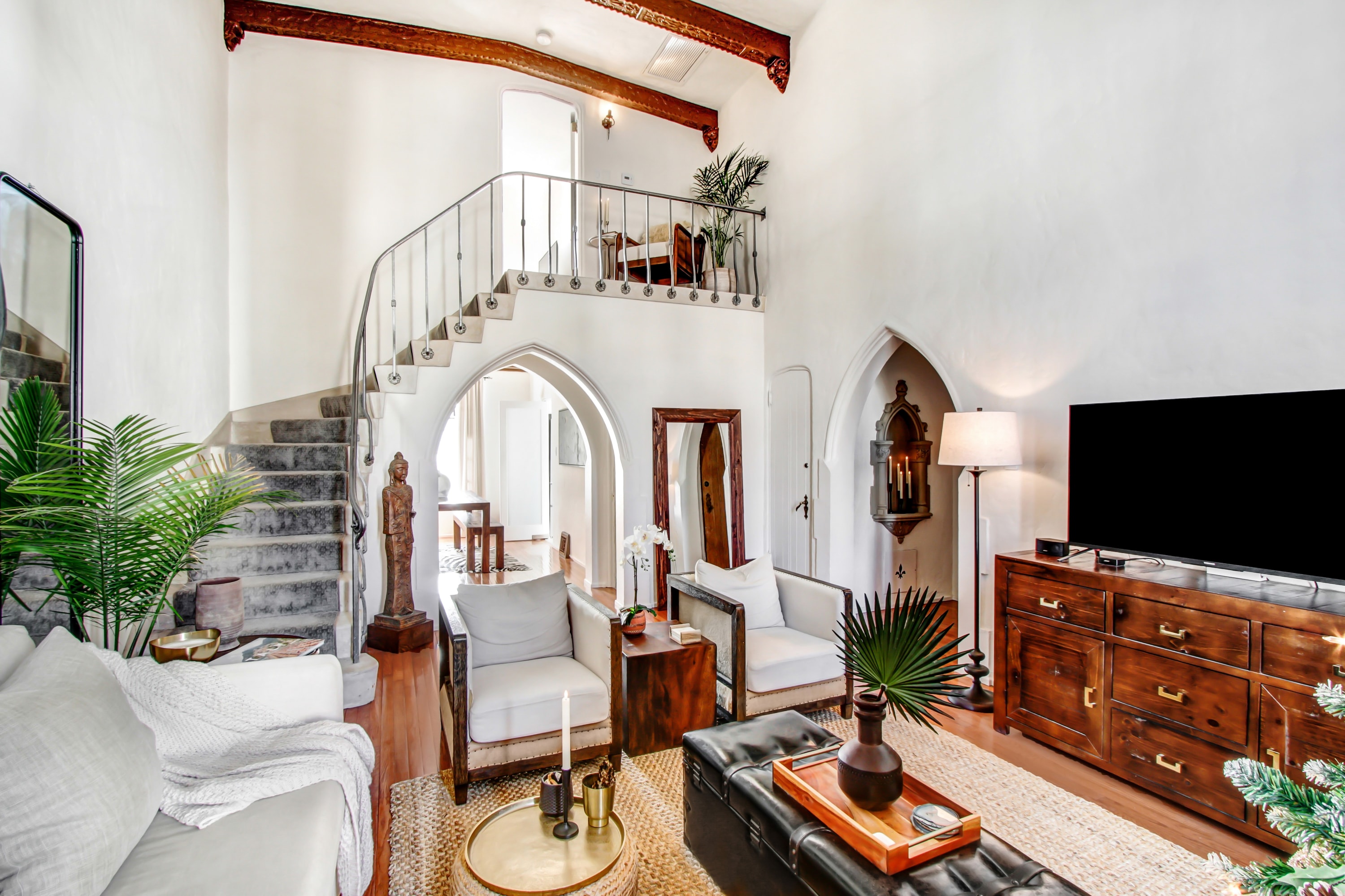Double-height living room with spiral staircase and ornate arched details