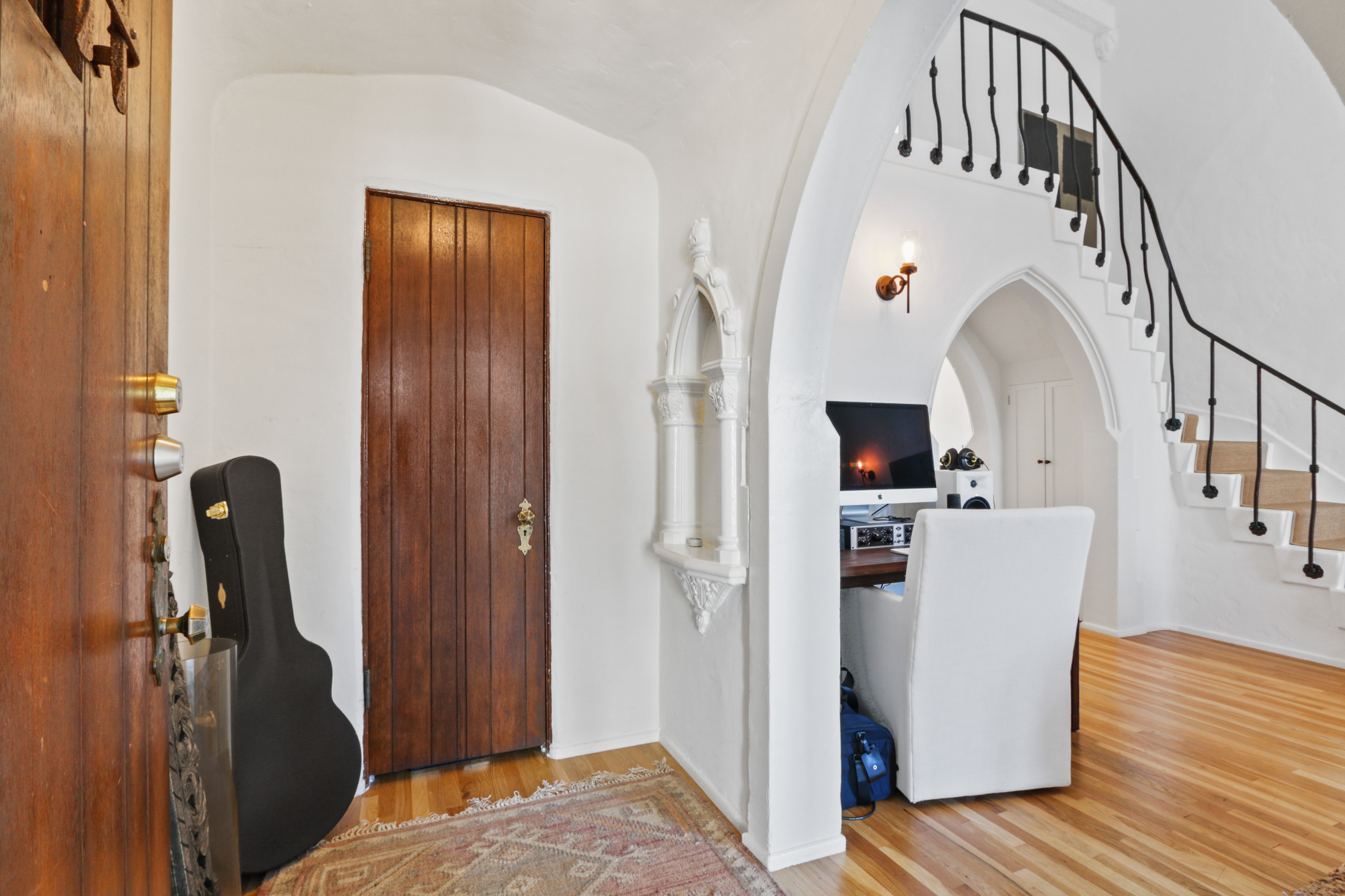 Entryway with arched ceilings, ornate woodwork and iron staircase