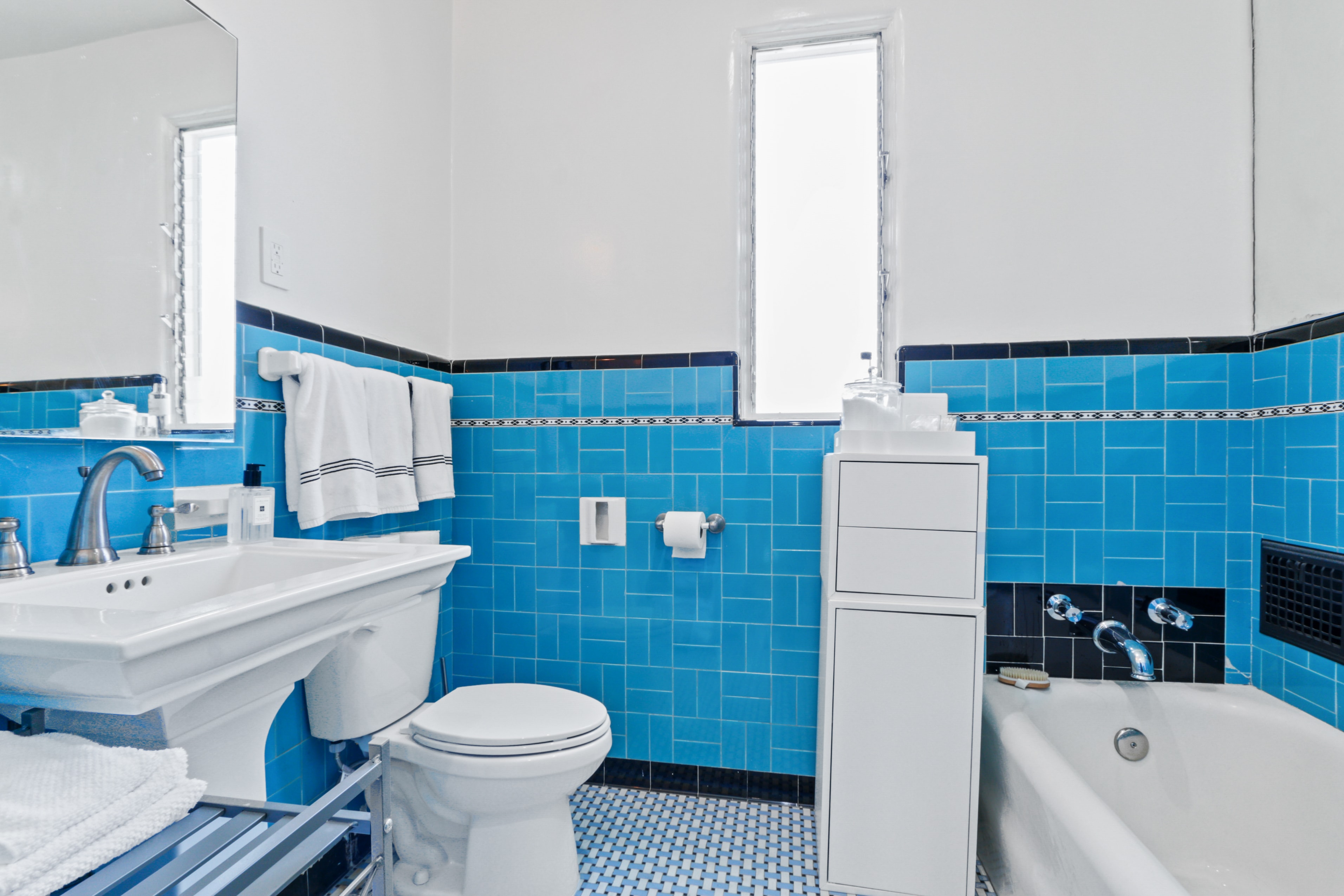 Original Art Deco bathroom with blue tile and soaking tub