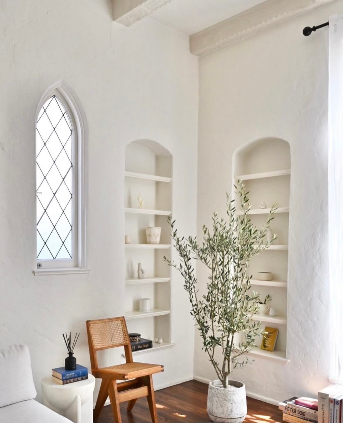 Bright living room with Gothic arched windows and built-in shelving