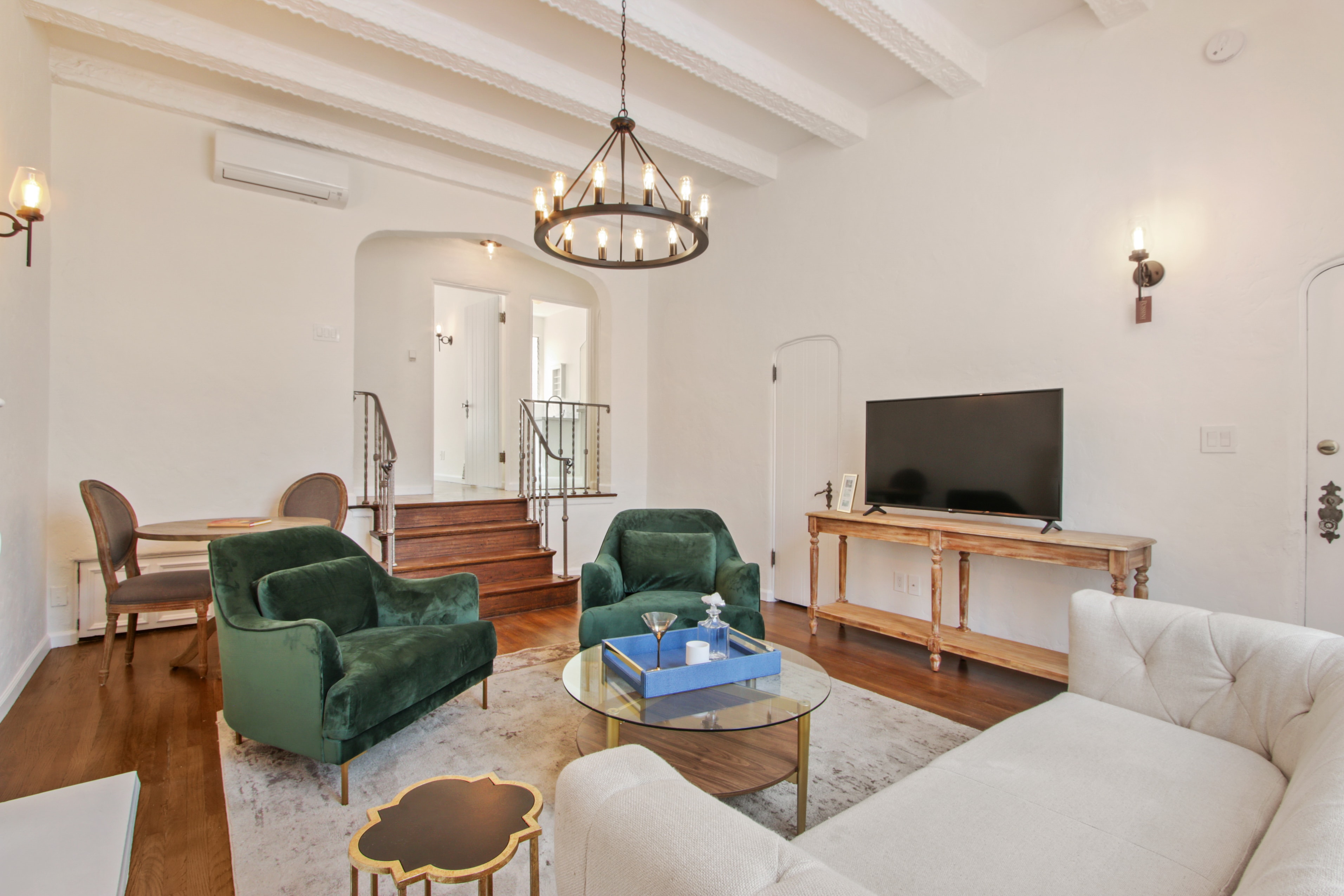 Open living room with exposed beamed ceilings and chandelier